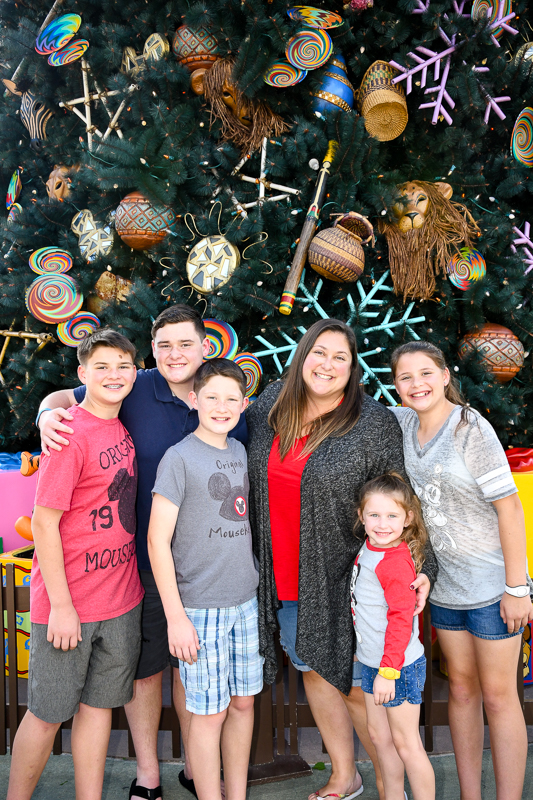Happy family in front of the Animal Kingdom Christmas tree