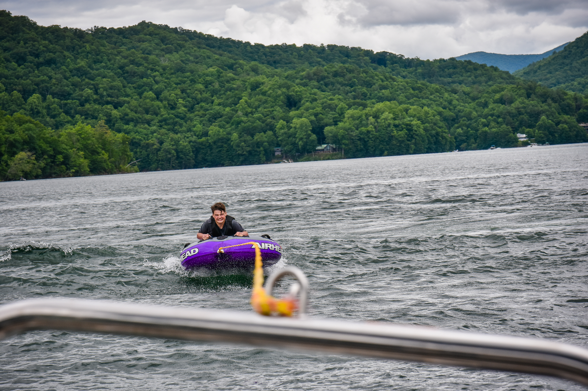Teen enjoying inflatable tube from pontoon rental Lakes End Marina Nantahala Lake