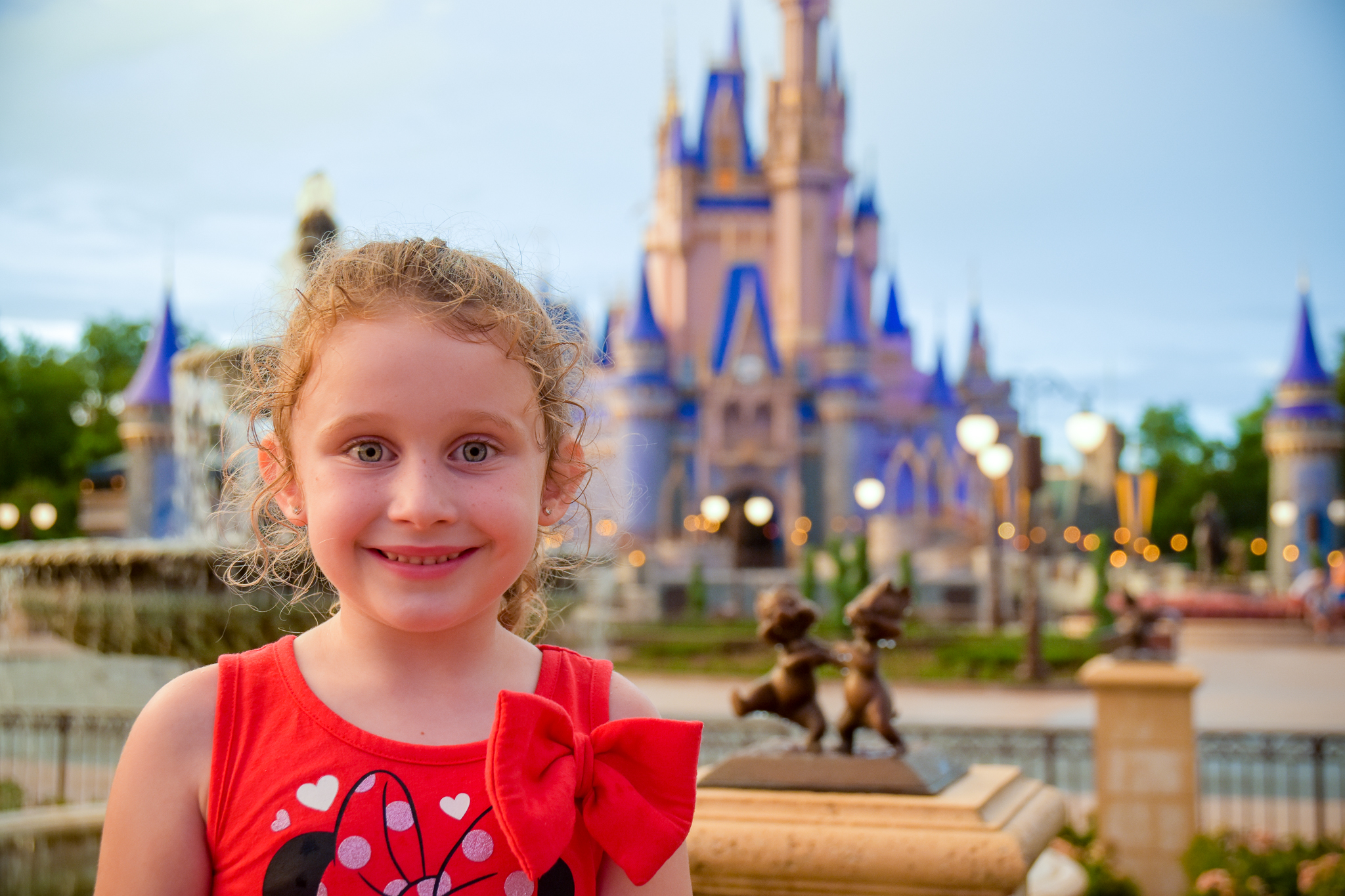 Smiling girl with Chip & Dale statue + Cinderella Castle