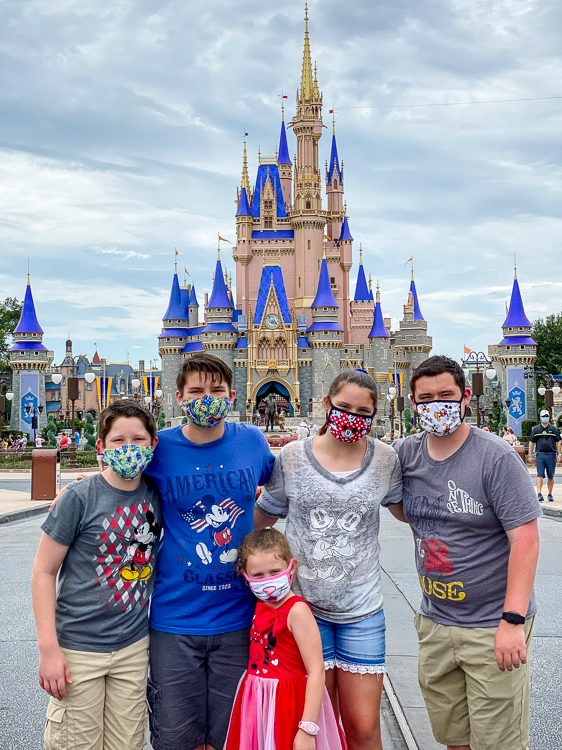 Family in masks at Cinderella Castle Magic Kingdom