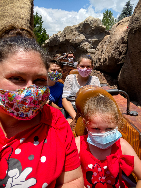 Family in masks on Seven Dwarfs Mine Train