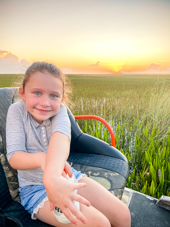 Smiling girl on airboat at sunset in Everglades