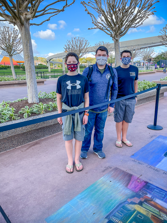 Masked teens looking at chalk art at FARTS