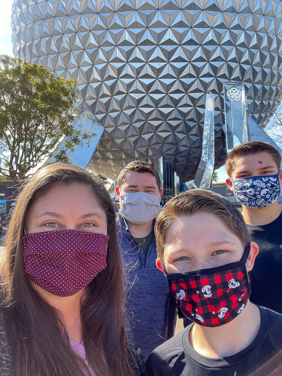 Masked teens with mom in front of Spaceship Earth at the EPCOT International Festival of the Arts
