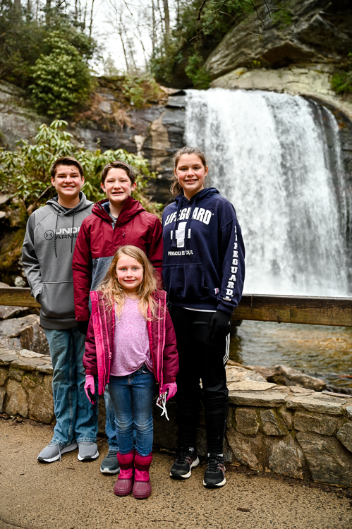 Smiling kids in front of waterfall