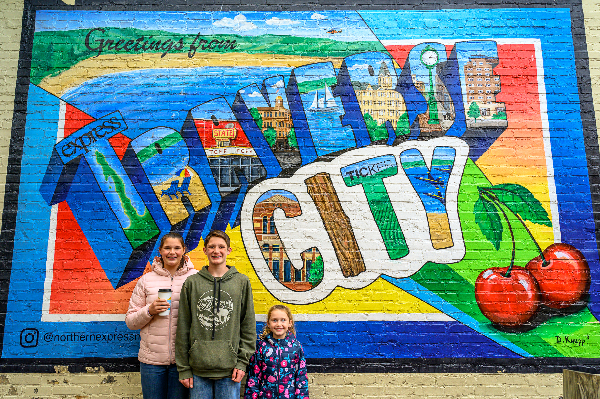 Traverse City with kids in front of mural