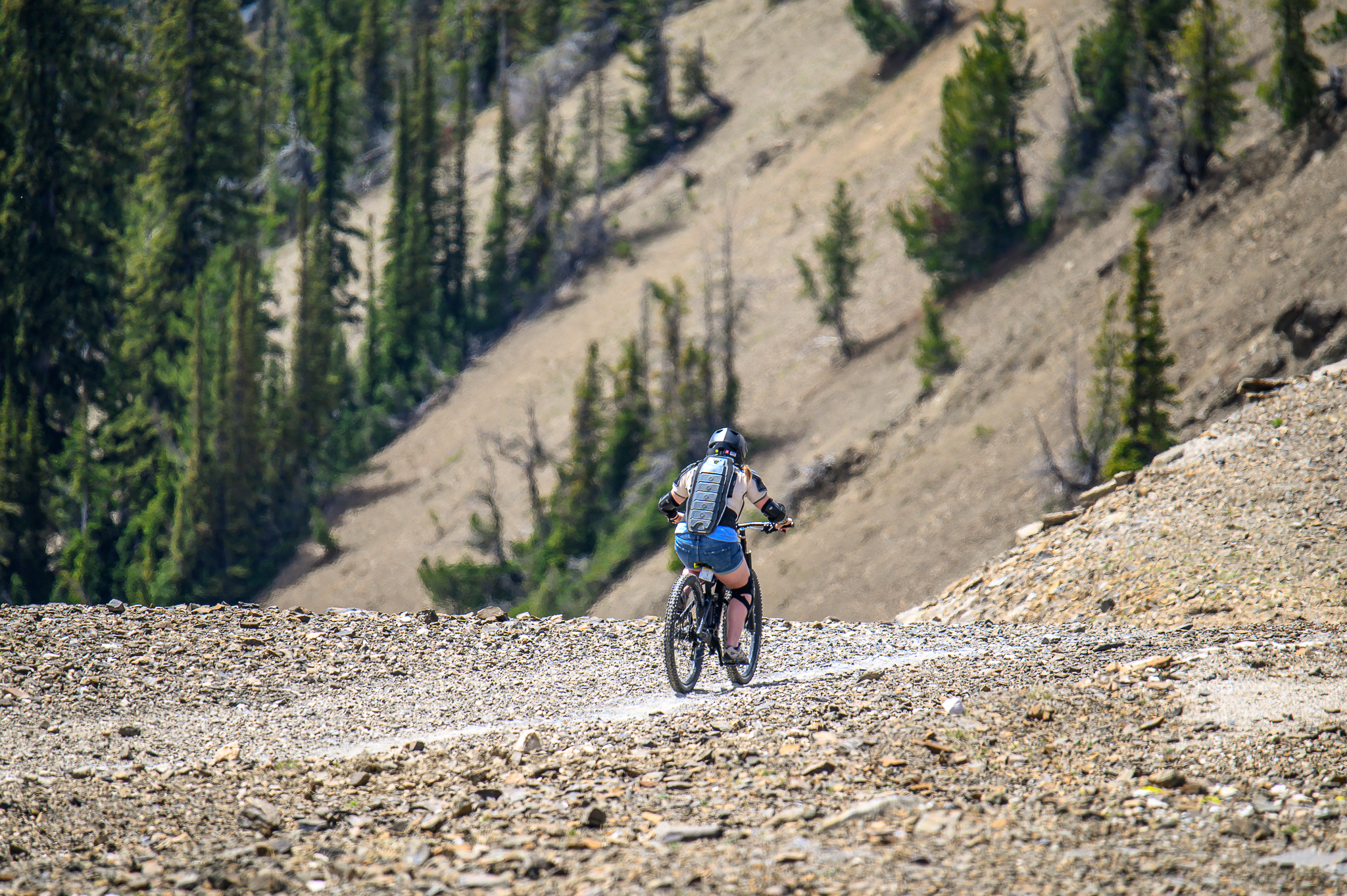 girl mountain biking down mountain Canada